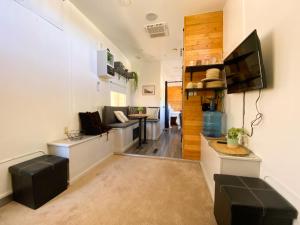 a living room with a couch and a tv on a wall at Boutique Campers La Ventana, a pasos de la playa in La Ventana