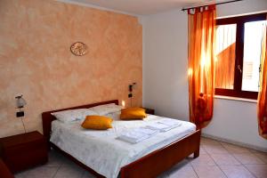 a bedroom with a bed with yellow pillows and a window at La casa dei nonni in Soave