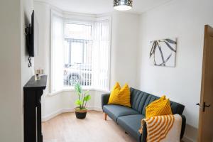 a living room with a blue couch and yellow pillows at The Butterfield in Liverpool