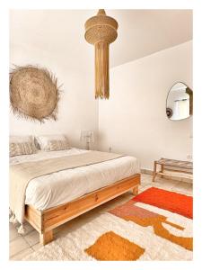 a bedroom with a large bed and a chandelier at Villa Habiba - Superbe maison avec piscine chauffée à Ghazoua in Ghazoua +22 photos