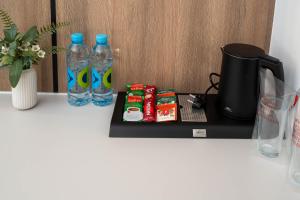 a counter with two bottles of water and a coffee maker at Hotel Cat Deluxe in Sanski most