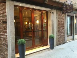 uma frente de loja com dois vasos de plantas em frente em Hotel Gorizia a La Valigia em Veneza