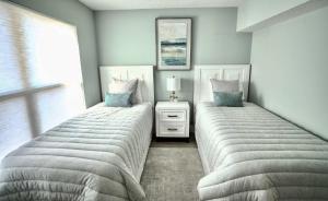 two twin beds in a bedroom with a window at Pier Point South Ocean View Condo C-34 in St. Augustine