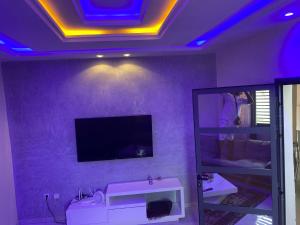 a bathroom with a mirror and a tv on the wall at Inss immo in Thiès +5 photos