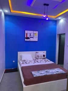 a blue room with a bed with a blue wall at Inss immo in Thiès