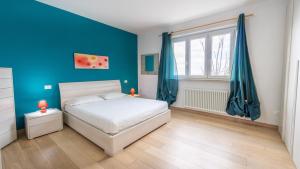 - une chambre avec un lit blanc et des murs bleus dans l'établissement Casa Bella vista, à Vallecchia