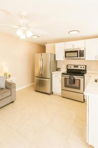 a kitchen with stainless steel appliances and a couch at Charming 1BR Canal Front Retreat in Naples +41 photos