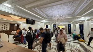 Un grupo de personas caminando por el vestíbulo de un hotel. en Hotel Ark Premium, en Bukhara 87 fotos más