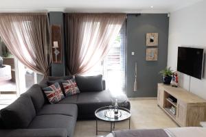 a living room with a couch and a tv at Simply The Choice Manor in Cape Town
