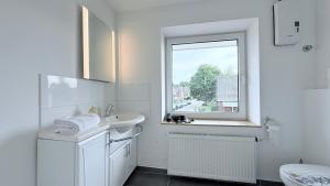 a white bathroom with a sink and a window at Monteurwohnung Brunsbüttel zentrale Lage mit Parkplatz & Schleusenblick in Brunsbüttel +52 photos