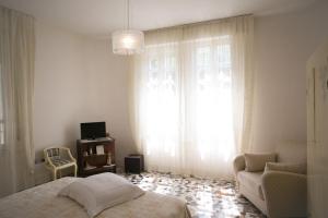 a bedroom with a bed and a chair and a window at B&B Casa Dei Grilli in Longiano