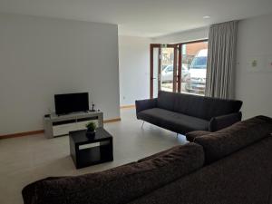 a living room with a couch and a tv at Casas do Maranhão Póvoa de Varzim in Navais