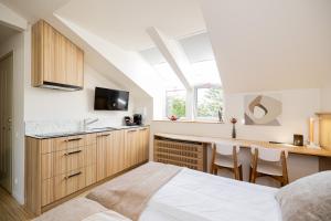 1 dormitorio con 1 cama y cocina con escritorio en Embassy Studio 303, en Vilna