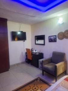 Una sala de estar con un sofá, una silla y un escritorio. en Joy studio apartment lekki phase 1, en Araromi