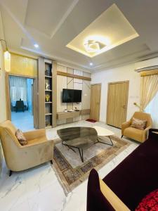 a living room with a couch and a table at Viklis Luxury Apartments in Port Harcourt