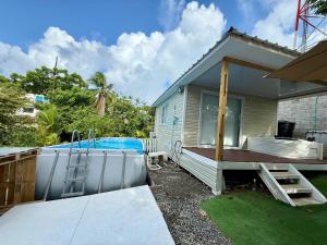 a small house with a swimming pool and a deck at Casa taj beach house in La Loma