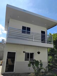 Una casa blanca con un balcón encima. en Villas Oasis Verde, en Salcoatitán