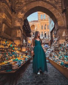 a woman in a green dress standing in a market at One Season Cairo in Cairo