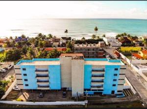 an aerial view of a building and the ocean at Flat mar e sol 106 praia de porto de galinhas in Porto De Galinhas