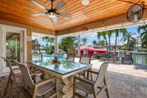 un patio con tavolo e sedie e una piscina di Waterfront Paradise a Holmes Beach