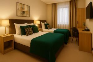 a hotel room with two beds with green sheets at Xetai Royal Hotel in Baku