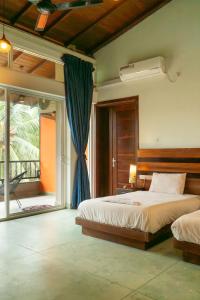 a bedroom with a bed and a large window at The Royal Peak Resort in Ratnapura