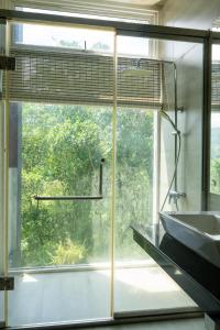 a bathroom with a large window and a sink at The Royal Peak Resort in Ratnapura