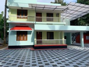 a white house with a red roof and a courtyard at Serenity Retreat in Varkala