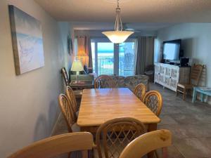 a dining room and living room with a wooden table and chairs at Relaxing Poolside Ocean View Townhouse Condo C-32 in Saint Augustine Beach