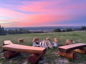 a group of logs and benches in a field at Domki Baby Jagi in Krajno Pierwsze