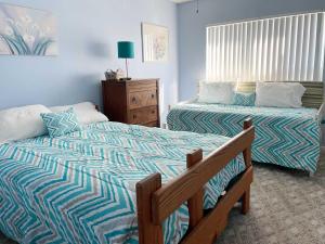 a bedroom with two beds and a dresser at Pier Point South Ocean View Townhouse Condo D-49 in Saint Augustine Beach