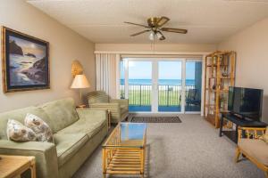 a living room with a couch and a television at Pier Point South Oceanfront Townhouse Condo A-8 in Saint Augustine Beach