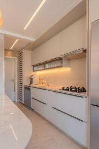 a kitchen with white cabinets and a counter top at JG Flecheiras in Trairi