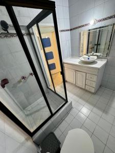 a bathroom with a toilet and a sink and a mirror at Casa Cocora in Bogotá