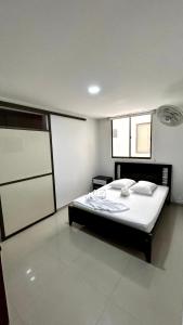 a bedroom with a bed with white sheets and pillows at Hotel Imperio in Ibagué +43 photos