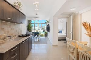 Una cocina con fregadero y una sala de estar. en ‏ Dizengoff Duplex - Center Tel Aviv, en Tel Aviv