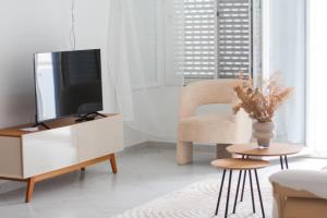 een woonkamer met een tv en een stoel bij Apartment Morabeza in Praia Cidadela in Praia