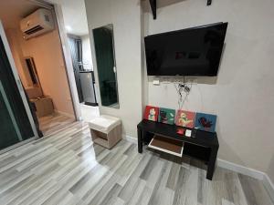 a living room with a flat screen tv on the wall at Secret Pastel Room Laksi Donmuang Airport ห้องลับพาสเทลหลักสี่สนามบินดอนเมือง in Lak Si