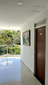 a hallway with a door in a building with a window at Hotel Imperio in Ibagué