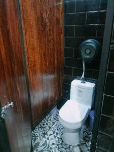 a bathroom with a toilet with a black tile wall at Hostal KEMMM in Mexico City +15 photos