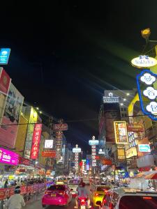a busy city street at night with cars and signs at LA CASA in China town in Bangkok