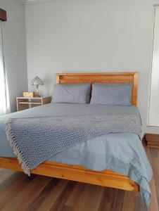 a bed with a wooden headboard in a bedroom at Yakhe self catering accommodation in Edenvale