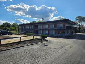 a building with a parking lot in front of it at Plaza Inn Springfield in Springfield