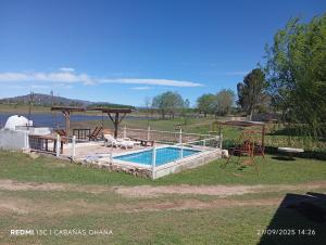 a swimming pool in a field next to the water at Ohana in Potrero de Garay