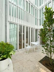 einen Innenhof mit einem Tisch und Stühlen in einem Gebäude in der Unterkunft housingcoruña RUA DO ANXO in A Coruña