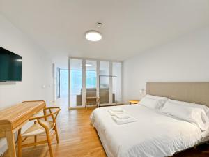 ein Schlafzimmer mit einem Bett, einem Tisch und einem Schreibtisch in der Unterkunft housingcoruña RUA DO ANXO in A Coruña