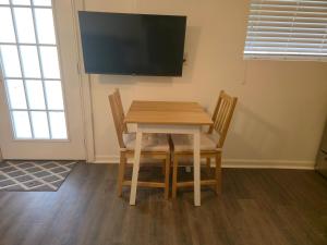 a dining room table with two chairs and a flat screen tv at 2224 Chapin Street in Tampa