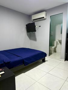 a bedroom with a blue bed and a bathroom at hotel gloria del norte sas in Cartagena de Indias