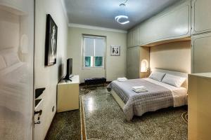 Un dormitorio con una cama y un televisor. en Manin Rail, en Génova