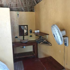 a bathroom with a sink and a fan on the wall at ecohabitas in Mazunte